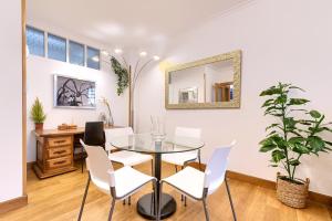 a dining room with a table and chairs and a mirror at Acogedor y Elegante Apartamento en Irala in Bilbao