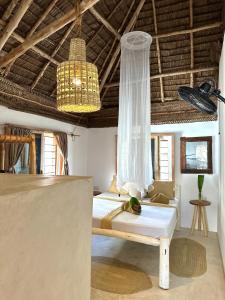 a bedroom with a bed and a chandelier at Mlango Paje Villa Boutique in Paje