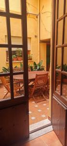 eine offene Tür zu einer Terrasse mit einem Tisch und Stühlen in der Unterkunft La casa del Rollo in Pasarón