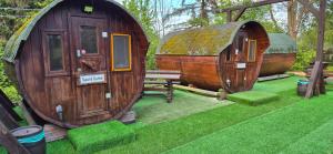 a couple of small houses with a bench in a yard at Mini Hotel Übernachten Im Gurkenfass in Lübbenau