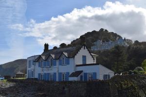 una casa blanca con un castillo en la cima de una colina en Rock House Hotel, en Lynmouth