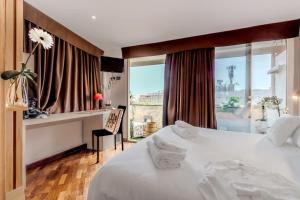 a hotel room with a bed and a desk and a window at Il Panoramico Rooms in Cagliari