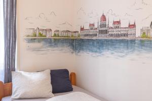 una camera da letto con un murale di un edificio appeso al muro di Gellerico Rooms at Deák Square a Budapest