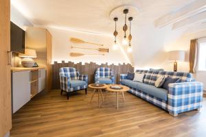 ein Wohnzimmer mit einem Sofa und 2 Stühlen in der Unterkunft Seeblick Genuss und Spa Resort Amrum in Norddorf