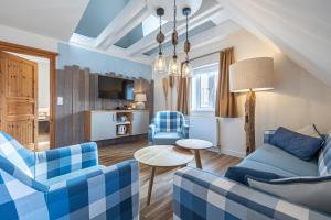 sala de estar con sillas azules y mesa en Seeblick Genuss und Spa Resort Amrum, en Norddorf