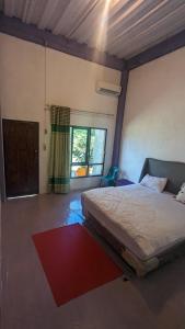 a bedroom with a bed and a large window at Taman Baloho Indah - Hotel & Resort in Telukdalam