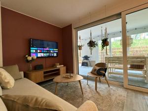 a living room with a couch and a flat screen tv at Familienurlaub im Schwarzwald, Europapark-Nähe in Ettenheim