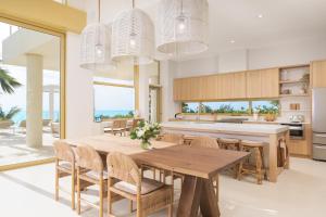 cocina y comedor con mesa de madera y sillas en Kailoa Villa en Long Bay Hills