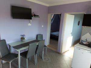 eine Küche und ein Esszimmer mit einem Tisch und Stühlen in der Unterkunft Corner Apartman 5 in Siófok