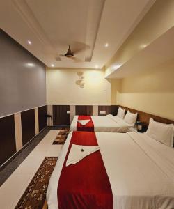 een hotelkamer met 2 bedden met rood en wit bij HOTEL Bodhi Tree in Patna