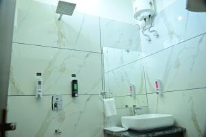 W białej łazience znajduje się umywalka i lustro. w obiekcie Aijasvan Resort w mieście Sawai Madhopur