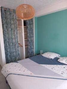1 dormitorio con 1 cama con pared azul en Appartement 1er étage, 66 m² en La Seyne-sur-Mer