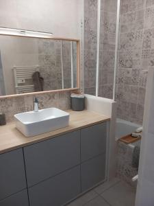 y baño con lavabo, espejo y bañera. en Appartement 1er étage, 66 m² en La Seyne-sur-Mer