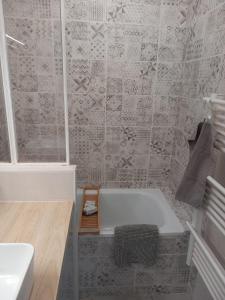 y baño con bañera y lavamanos. en Appartement 1er étage, 66 m² en La Seyne-sur-Mer
