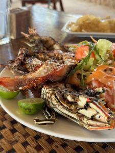 a plate of food with crabs and vegetables on a table at Kiwengwa Bungalow Boutique Resort in Kiwengwa