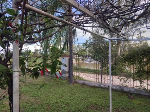 une pergola blanche dans une cour avec une clôture dans l'établissement Chalet Del Lago, à Termas de Río Hondo