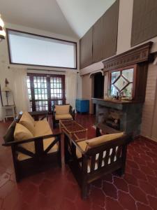 - un salon avec un canapé et une cheminée dans l'établissement Chalet Del Lago, à Termas de Río Hondo