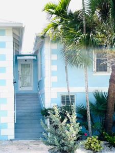 una casa azul con palmeras delante en 30 Sec Walk to Beach, en Nassau