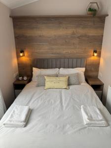 a large white bed with two towels on it at Sea La Vie Lodge in New Quay