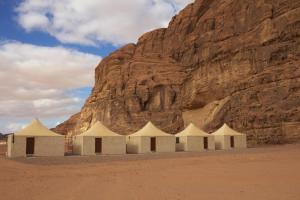 grupa namiotów przed górą w obiekcie Remal Wadi Rum Camp & Tour w mieście Disah