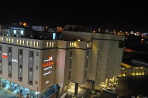 un grand bâtiment avec un panneau la nuit dans l'établissement Manazel Aldana, à Abha