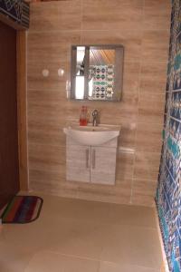 a bathroom with a sink and a mirror at Remal Wadi Rum Camp & Tour in Disah