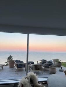 a room with a view of the ocean from a deck at Denmark's Most Charming Beach Cottage in Kalundborg