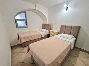 two beds in a small room with a window at Kazanegra Exclusive Apartments in Sveti Stefan