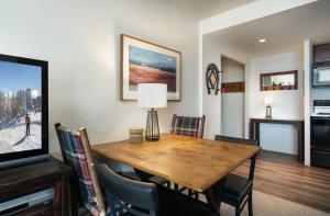 a dining room with a wooden table and a television at Trails End Easy Rest Condo: Ski In/Out, Stroll To Main Street in Breckenridge
