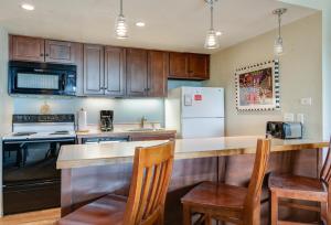 a kitchen with wooden cabinets and a counter top at Trails End Easy Rest Condo: Ski In/Out, Stroll To Main Street in Breckenridge +30 photos