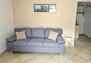 a blue couch with two pillows in a living room at Kazanegra Exclusive Apartments in Sveti Stefan