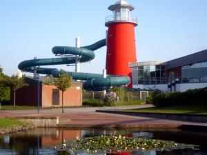 a lighthouse with a slide in front of a building at Windlicht im 1 Stockwerk in Norddeich