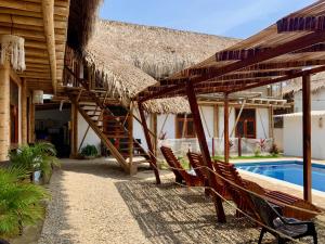 um resort com telhado de palha e uma piscina em Rincon del Mar Palomino em Palomino