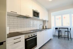 a white kitchen with a sink and a stove at Notel Club - Oasis urbano en Santander in Santander