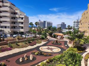 a garden with a clock in the middle of a city at Luxury Suite Borinquen in Playa de las Americas