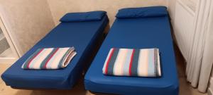 two blue beds with pillows sitting next to each other at Albergue Santiago Apostol in Logroño