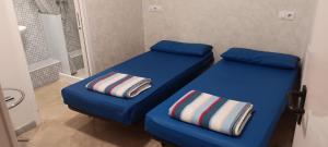 two beds in a small room with blue sheets at Albergue Santiago Apostol in Logroño