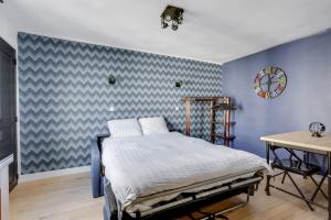 a bedroom with a bed and a blue wall at 129 Suite Haïm - Superbe Appartement à Paris. in Paris