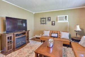 sala de estar con TV de pantalla plana grande en Cozy DuBois Home with Deck about 8 Mi to Treasure Lake!, en DuBois