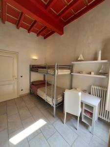 1 Schlafzimmer mit Etagenbetten, einem Tisch und einem Schreibtisch in der Unterkunft Appartamento di lusso Corso d'Augusto Rimini in Rimini