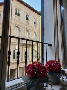 a window with a bunch of flowers and a building at Appartamento di lusso Corso d'Augusto Rimini in Rimini
