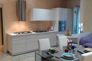 eine Küche mit weißen Schränken und einem Tisch mit Kerzen in der Unterkunft Appartamento di lusso Corso d'Augusto Rimini in Rimini