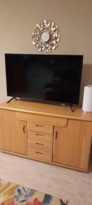 a flat screen tv on top of a wooden entertainment center at Stadtrandgeflüster-Ferienwohnung für 2 Personen in Krakow am See