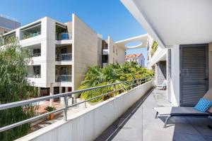 um apartamento varanda com uma cadeira e palmeiras em HSUD0118 Terracotta em Cannes