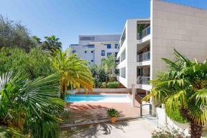 um edifício de apartamentos com piscina e palmeiras em HSUD0118 Terracotta em Cannes