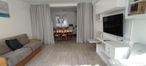 a living room with a couch and a flat screen tv at Hôtel Triotel in La Valette-du-Var