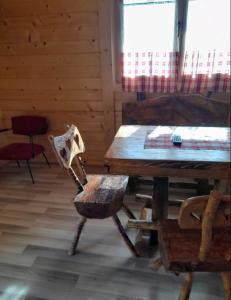 ein Esszimmer mit einem Holztisch und einem Stuhl in der Unterkunft Apartmani Suncevica in Arilje
