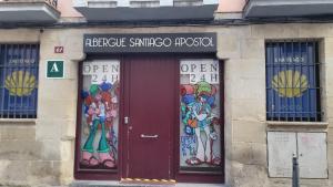 a building with two doors with paintings on it at Albergue Santiago Apostol in Logroño