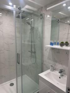 a bathroom with a glass shower and a sink at Luxury 2 bedroom apartment in Belper