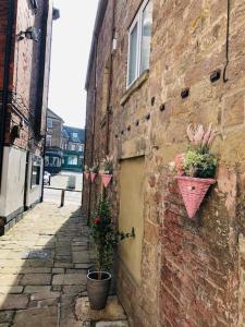 an alley with potted plants on the side of a building at Luxury 2 bedroom apartment in Belper